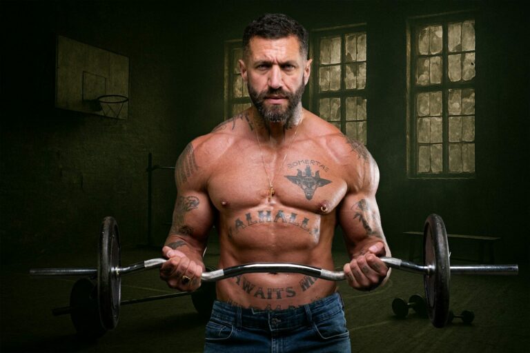 Man performs bicep curls with weights in the gym.